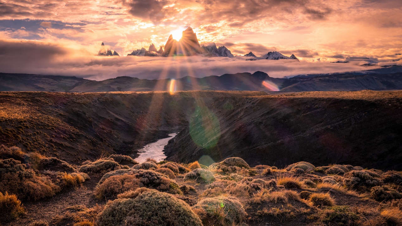 Лучи яркого солнца пробиваются сквозь вершину горы на рассвете 