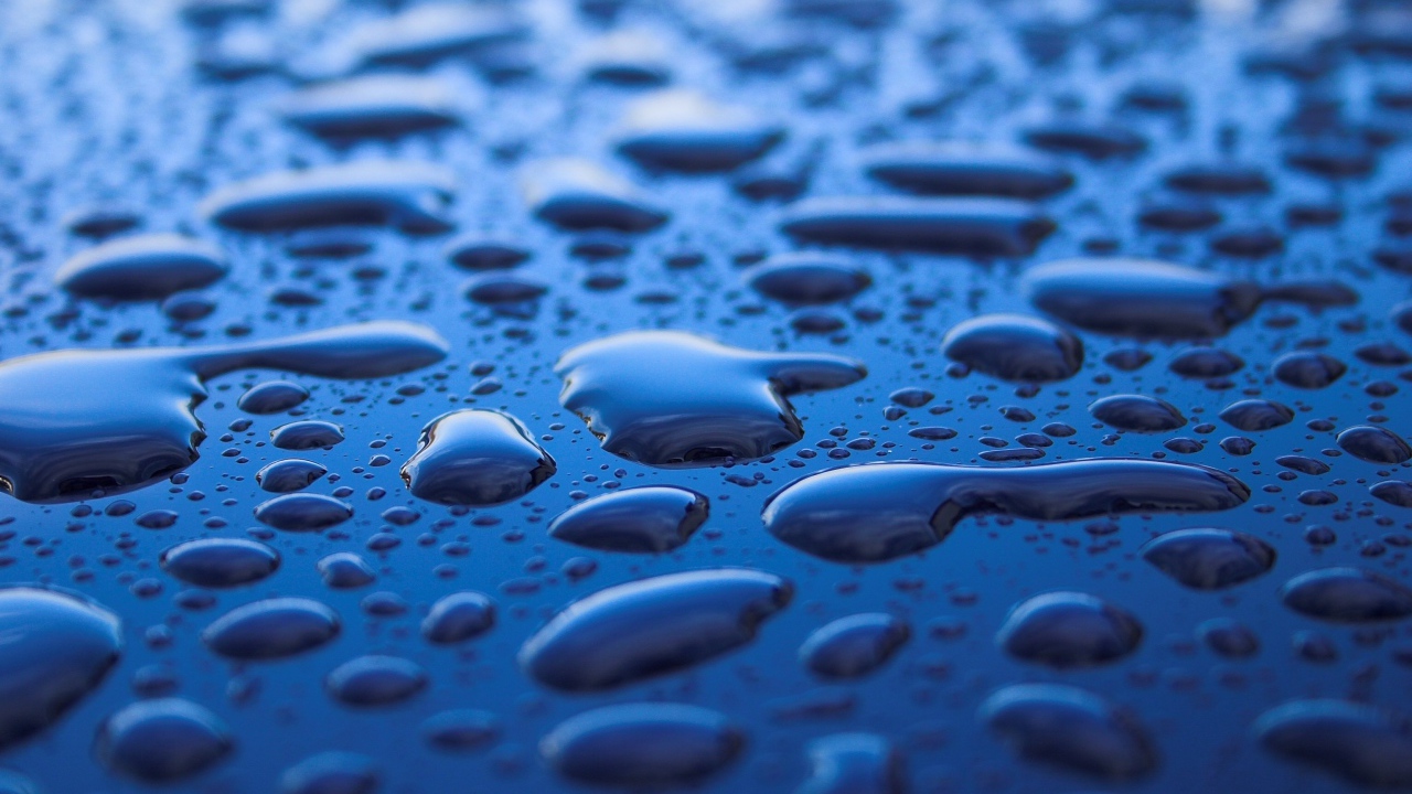 Капли дождя на черном поверхности 