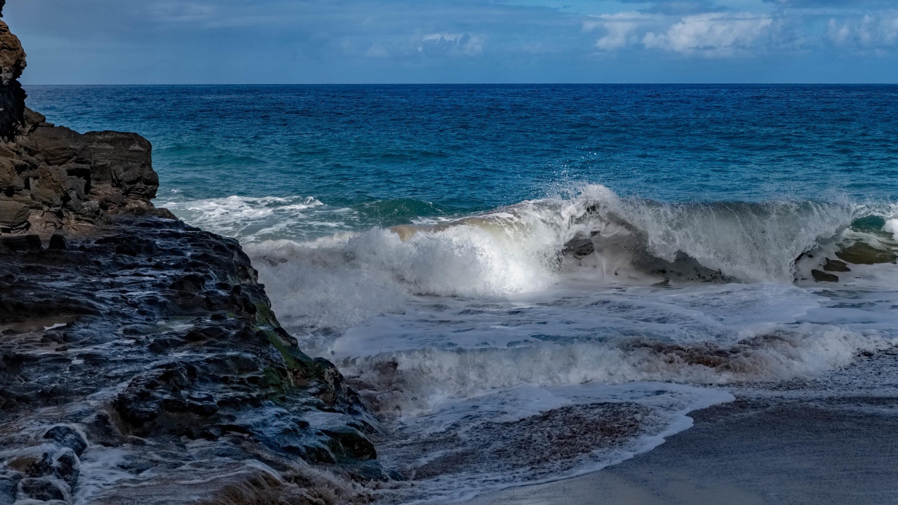 Бушующие белые волны в море у скал 