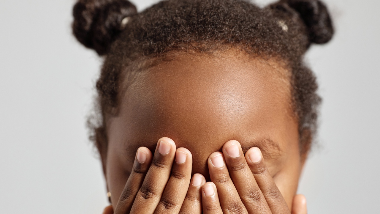 Темнокожая девочка закрыла глаза 