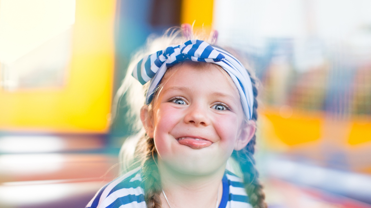 Забавная маленькая девочка с повязкой на голове