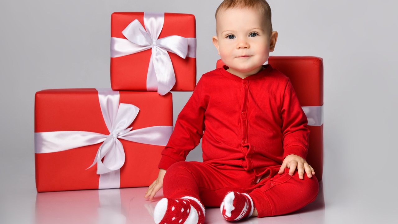 Маленький мальчик в красном костюме с подарками