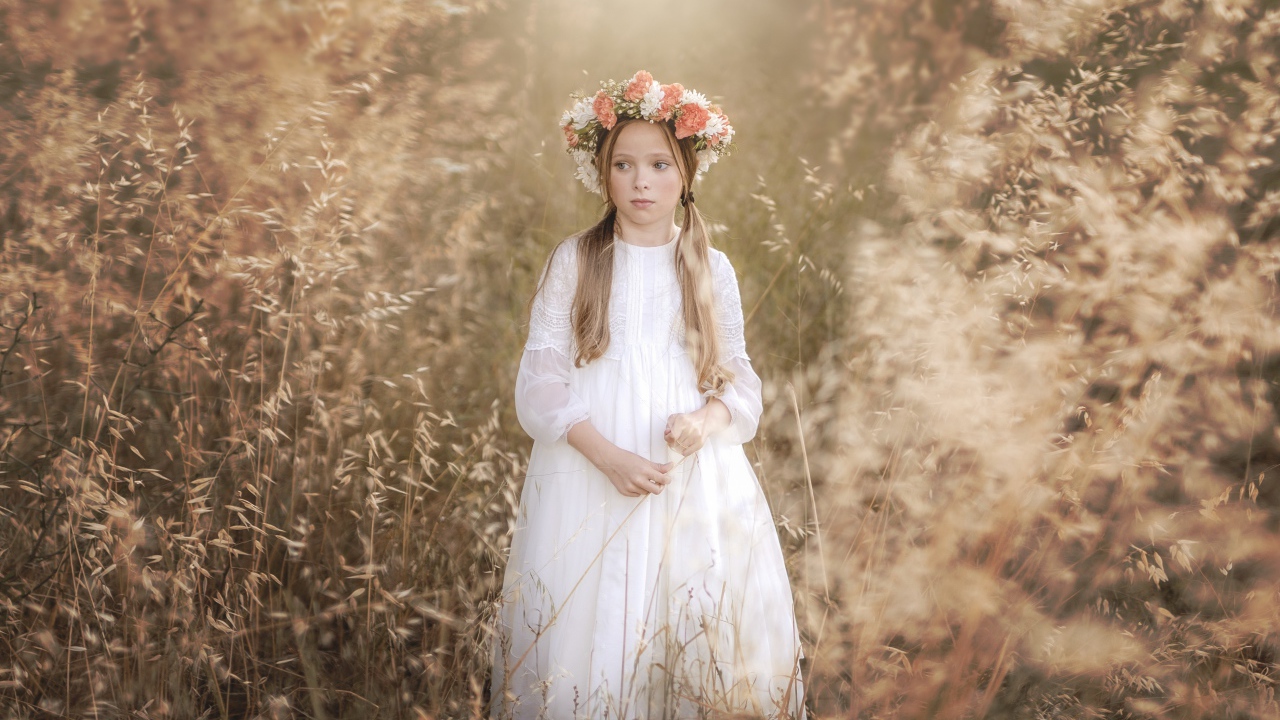 Маленькая девочка в белом платье с венком на голове 