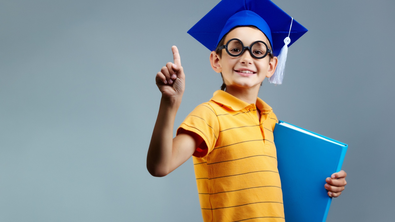 Маленький ученый мальчик с книгой в руке 