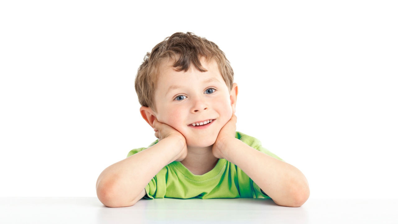 Маленький улыбающийся голубоглазый мальчик на белом фоне