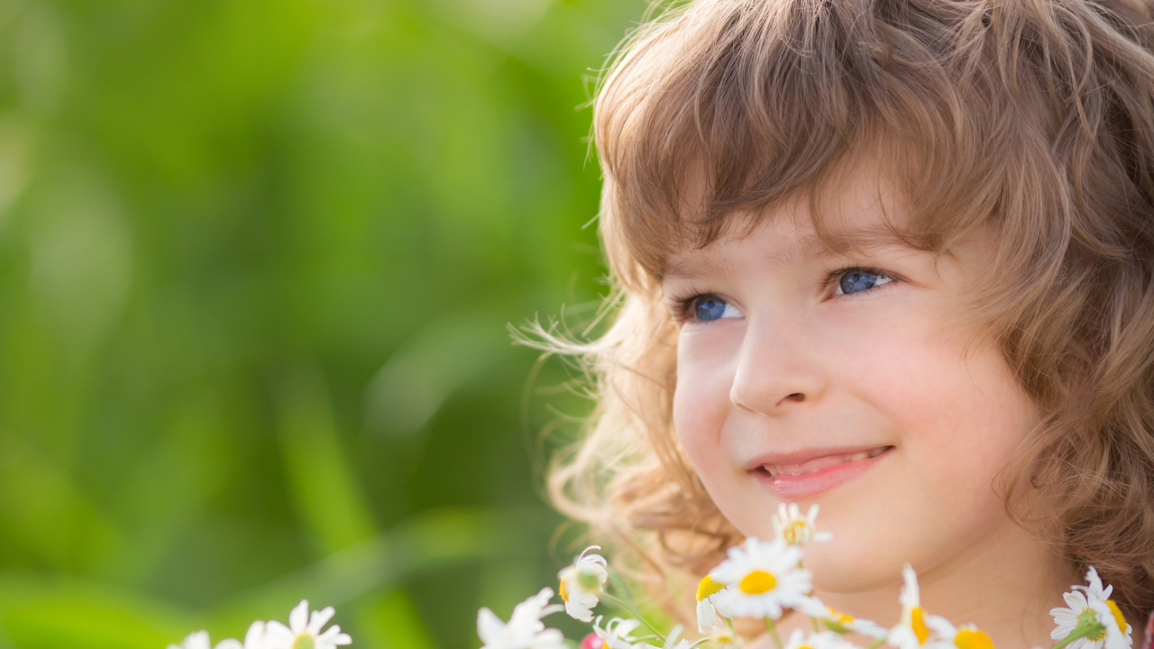 Улыбающаяся девочка с букетом ромашек 