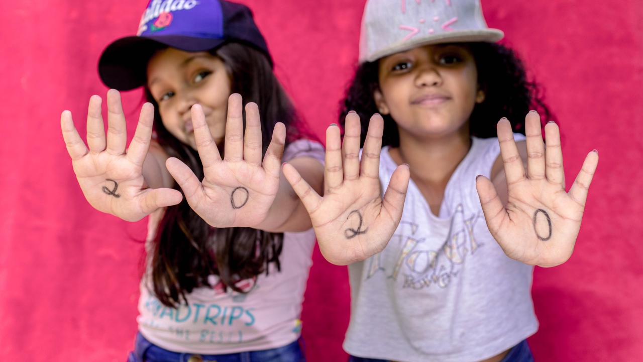 Две маленькие девочка с цифрами на ладонях 