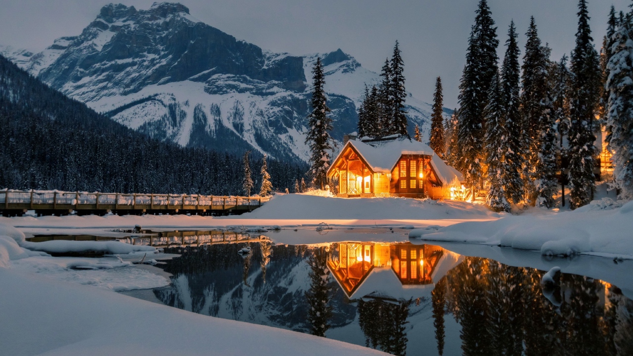 Дом на берегу горного озера зимой 