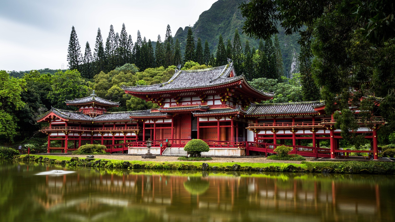 Красное здание храма у воды на фоне горы, Япония