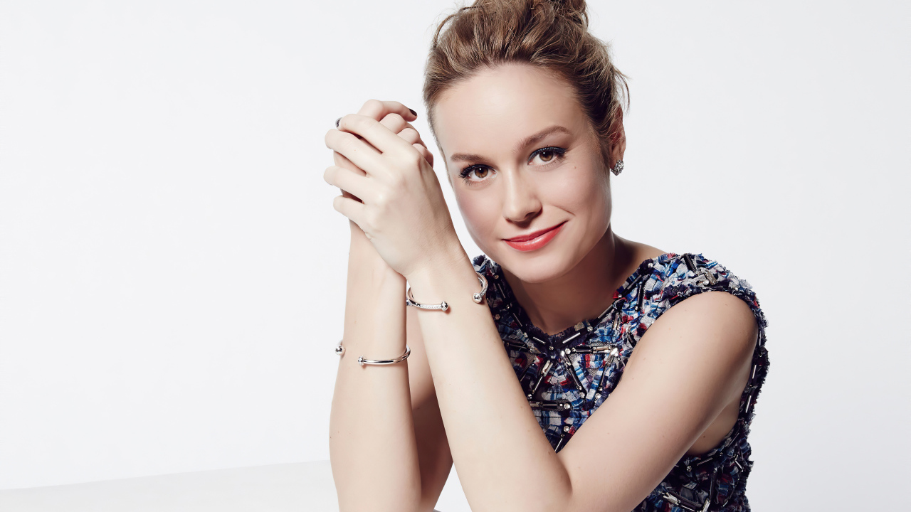 Актриса Бри Ларсон с милой улыбкой на белом фоне