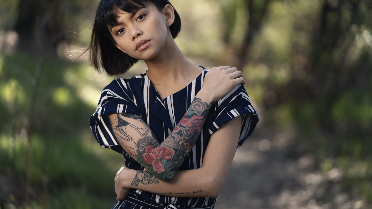 Красивая девушка азиатка с татуировками на руках 