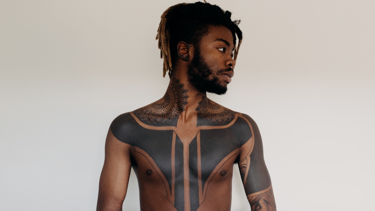 Темнокожий мужчина с татуировками на теле