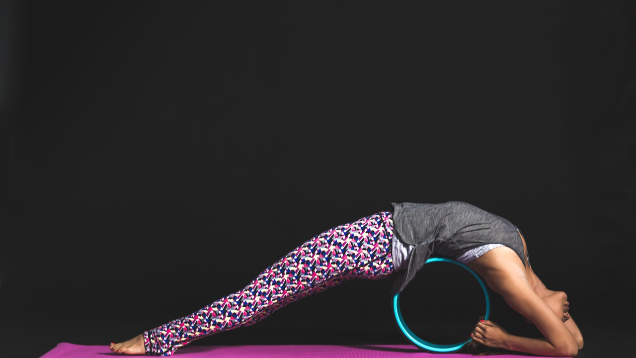 Девушка делает упражнения для спины на черном фоне