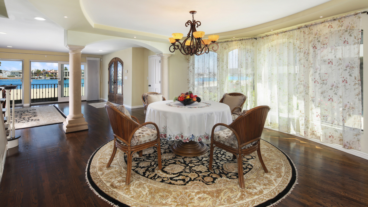 Большая гостиная комната с большими окнами и столом 