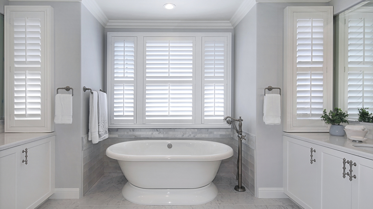Большая белая ванна в комнате с окнами