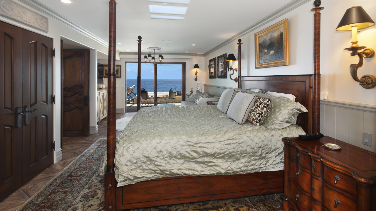 Большая деревянная кровать в спальне с видом на море 