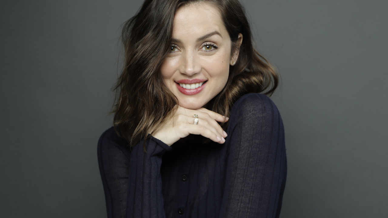 Улыбающаяся актриса Ана де Армас на сером фоне