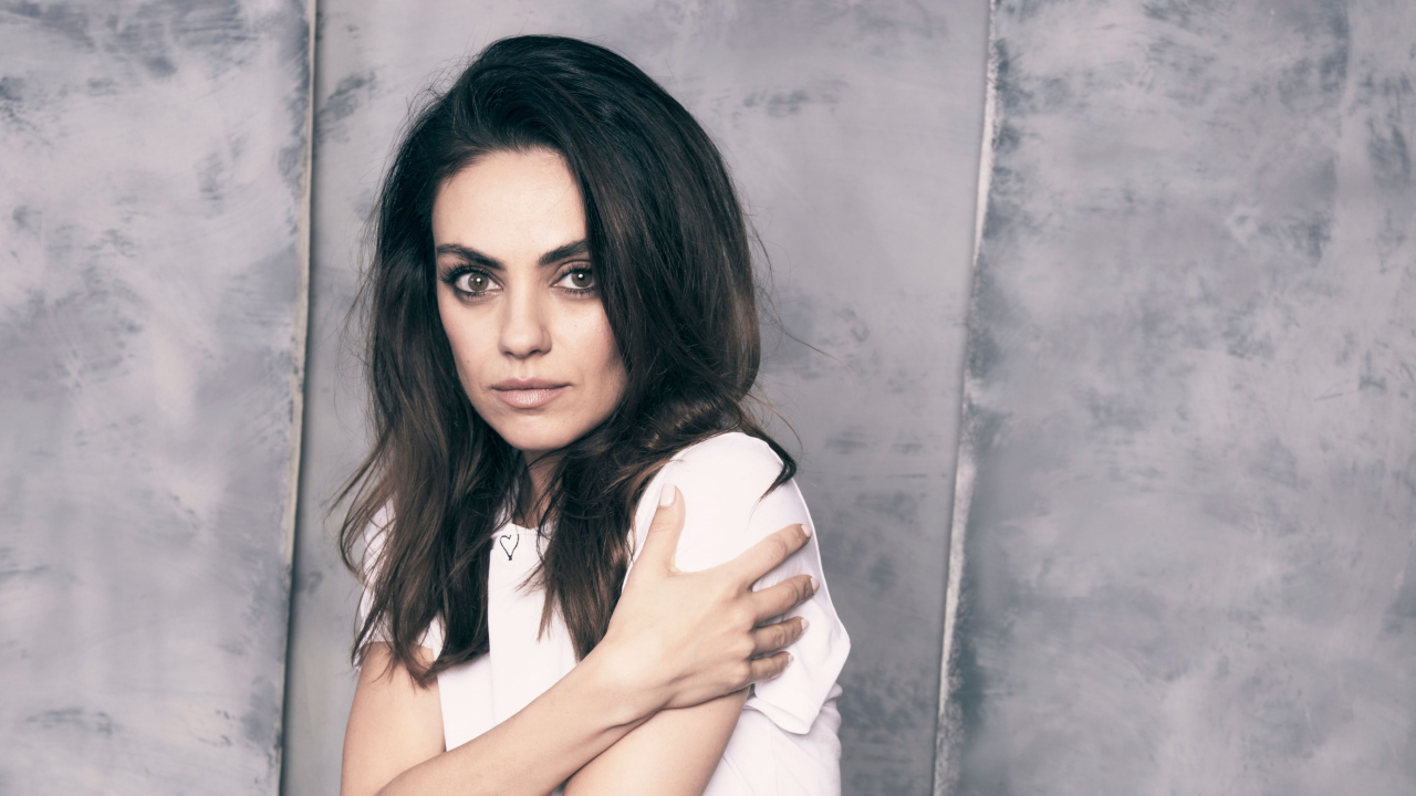 Нежная девушка, актриса Мила Кунис на сером фоне