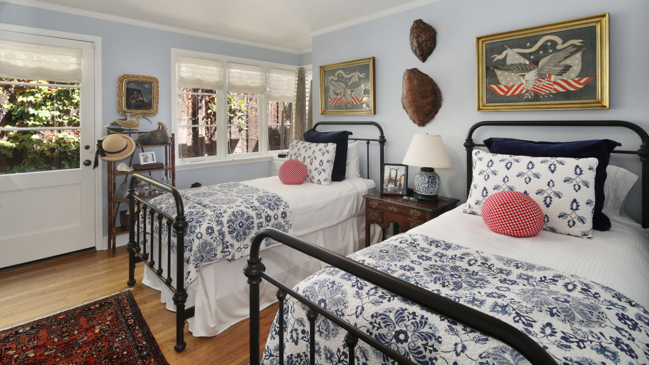 Две большие кровати в спальне с большими окнами