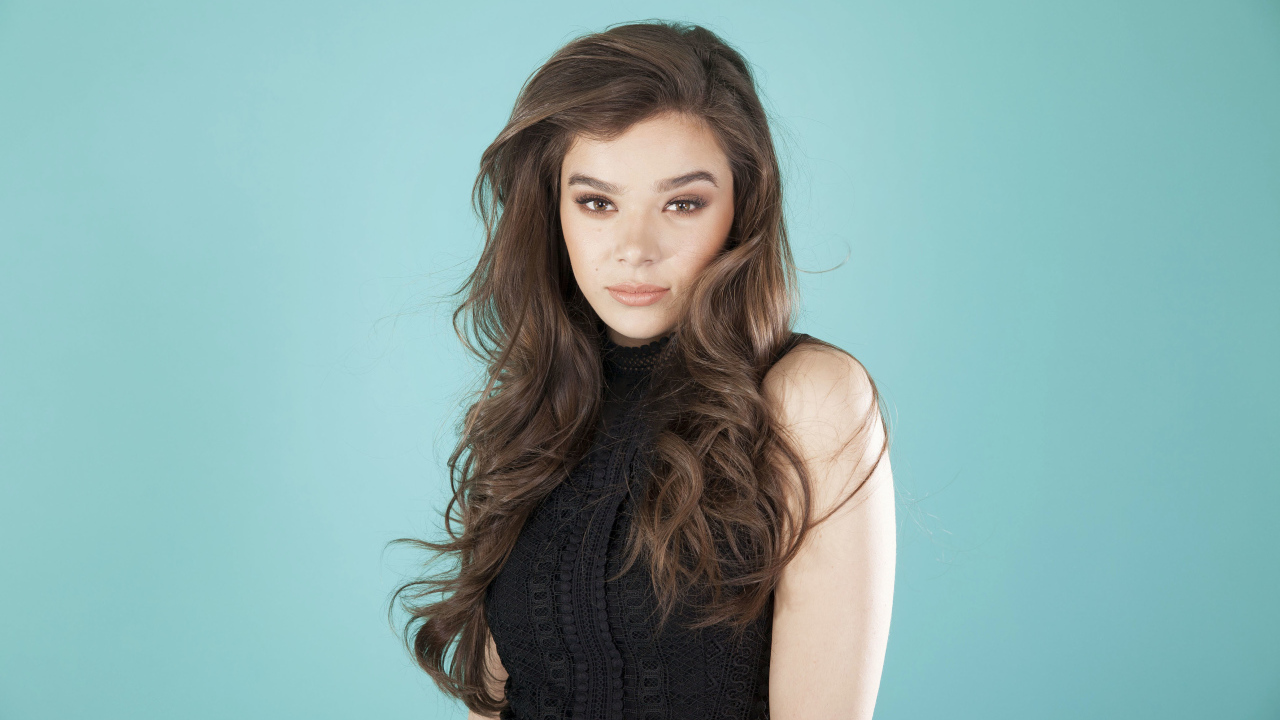 Молодая актриса Хейли Стейнфилд  в черном наряде на голубом фоне