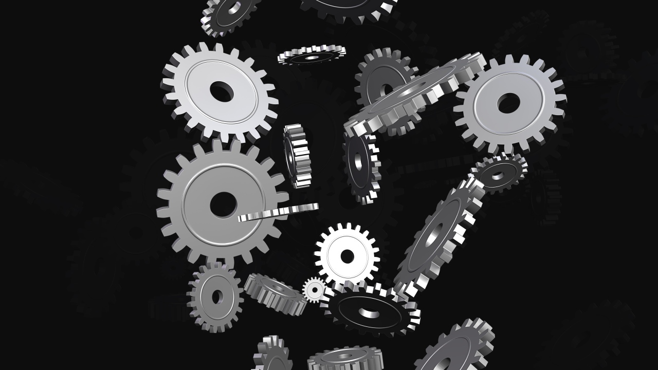 Металлические шестеренки в воздухе на черном фоне