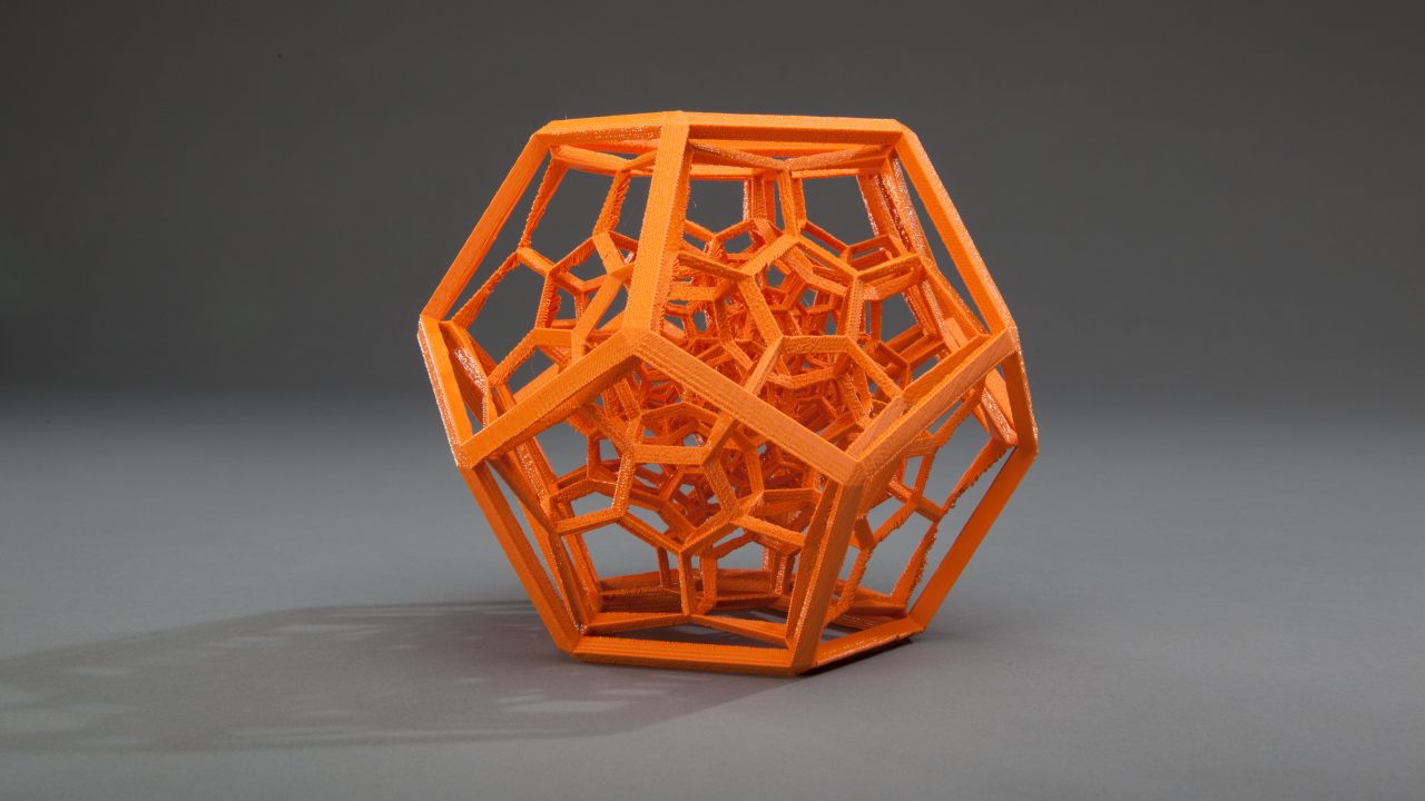 Оранжевый многогранник на сером фоне 3д