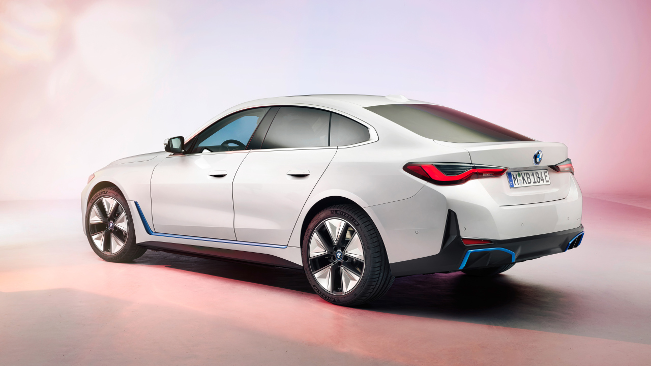 Белый автомобиль BMW I4 2021 года на розовом фоне