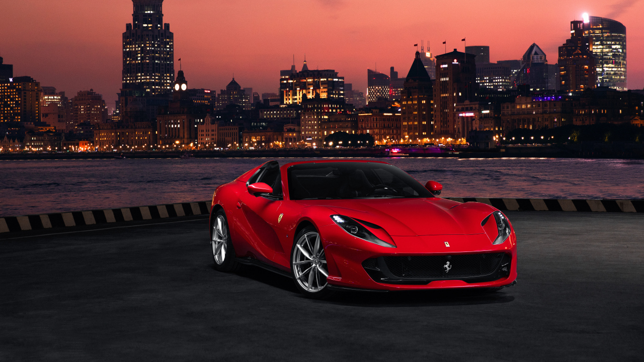 Красный автомобиль Ferrari 812 GTS  на фоне ночного города