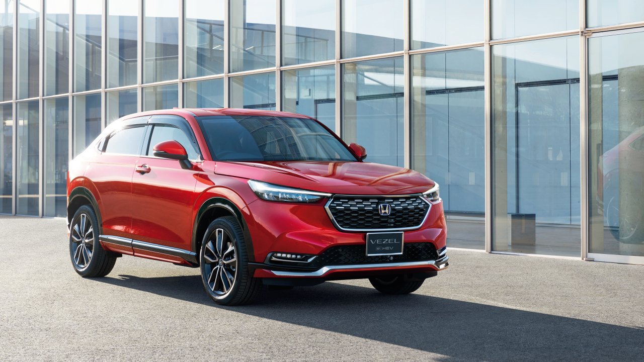 Красный автомобиль Honda Vezel EHEV 2021 у здания