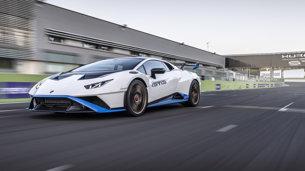 Белый автомобиль Lamborghini Huracán STO 2021 года на стадионе 