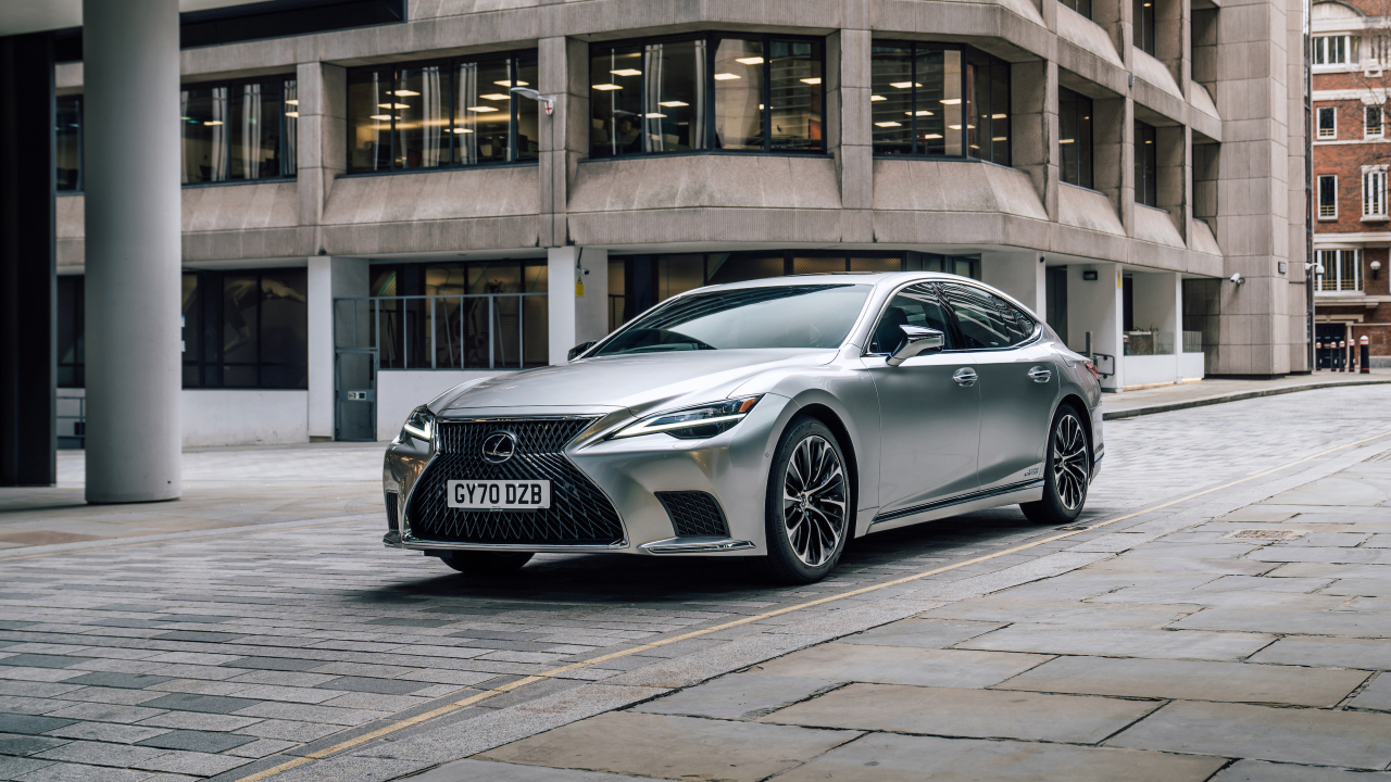 Серебристый автомобиль Lexus LS 500h 2021 года в городе у дома