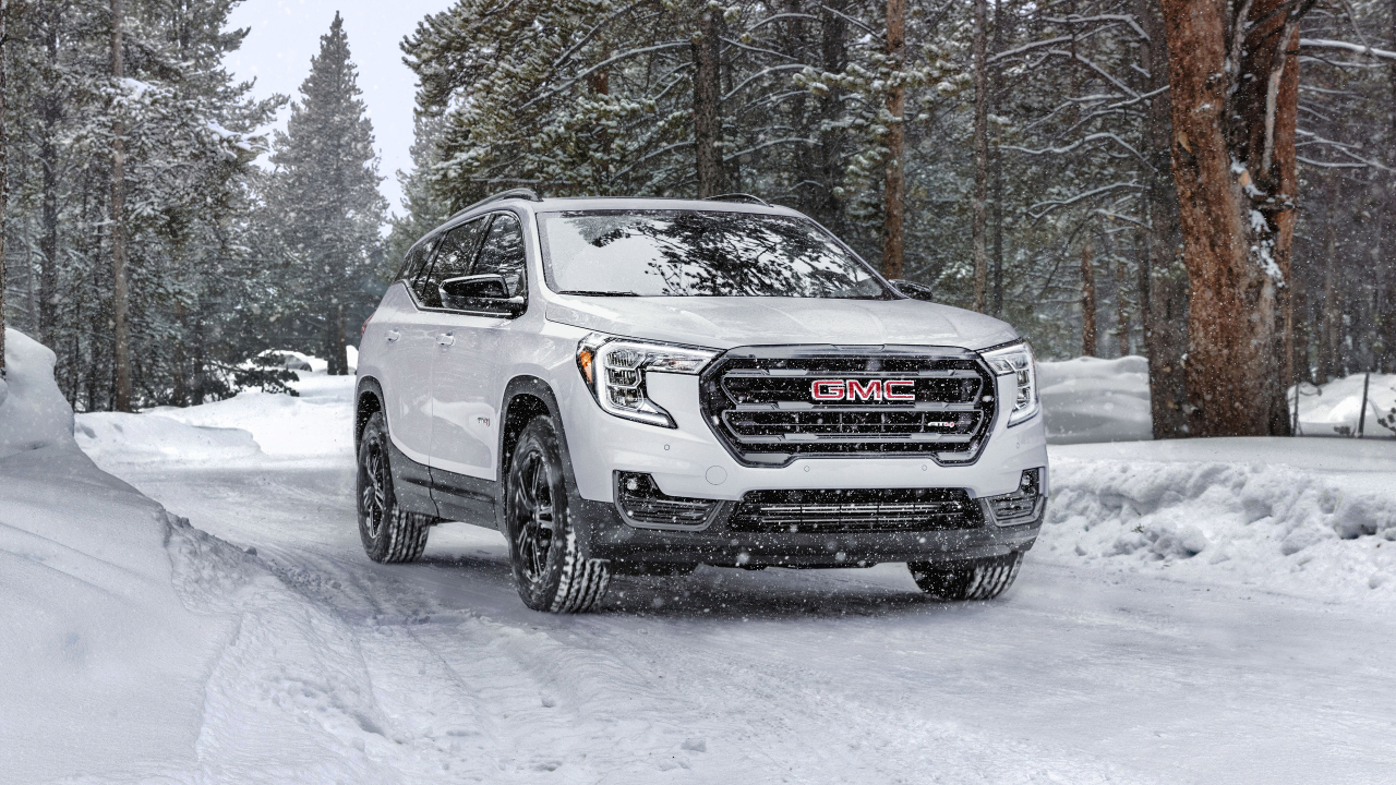 Большой белый внедорожник GMC Terrain AT4, 2022 года на снегу