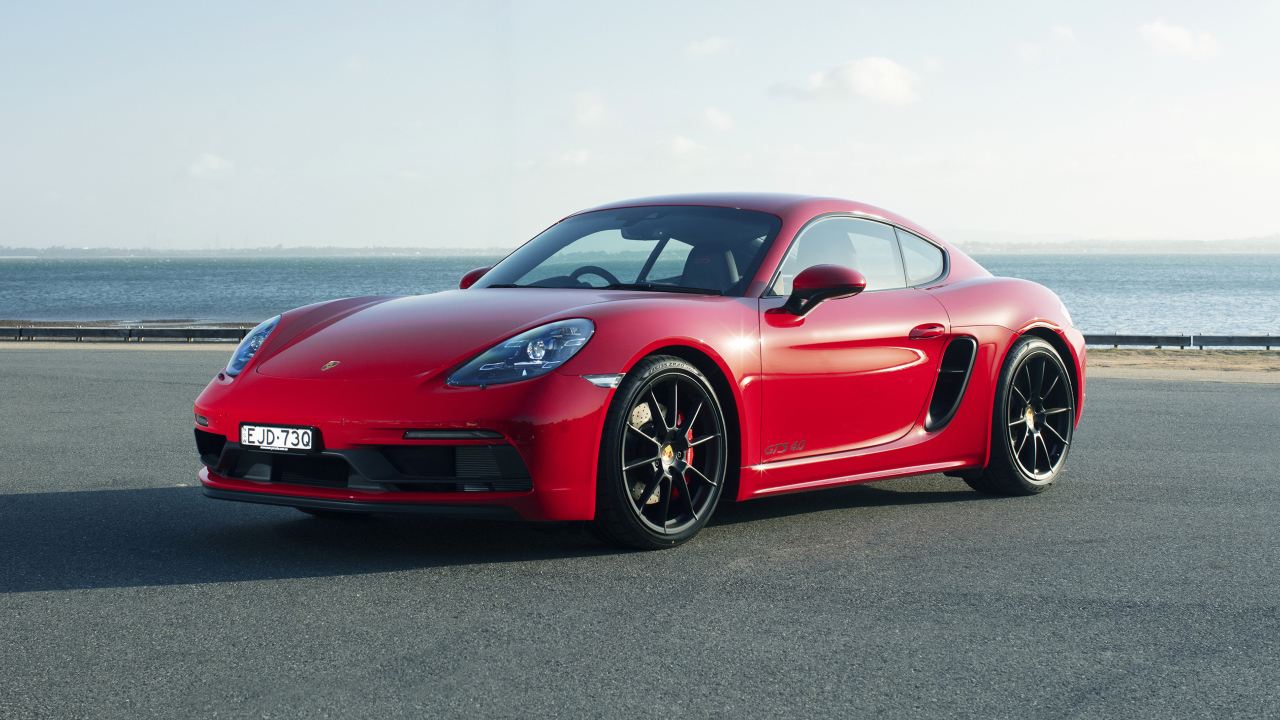 Красный автомобиль Porsche 718 Cayman GTS у моря