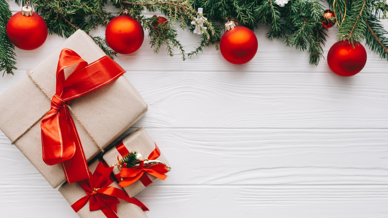 Подарки, еловая ветка и красные шары на Рождество 