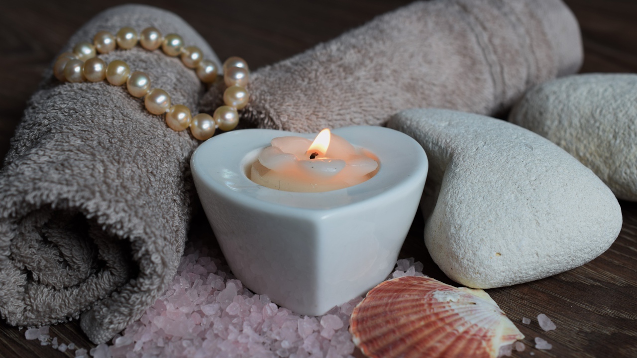 Красивая свеча с полотенцем, бусами, камнями и морской солью