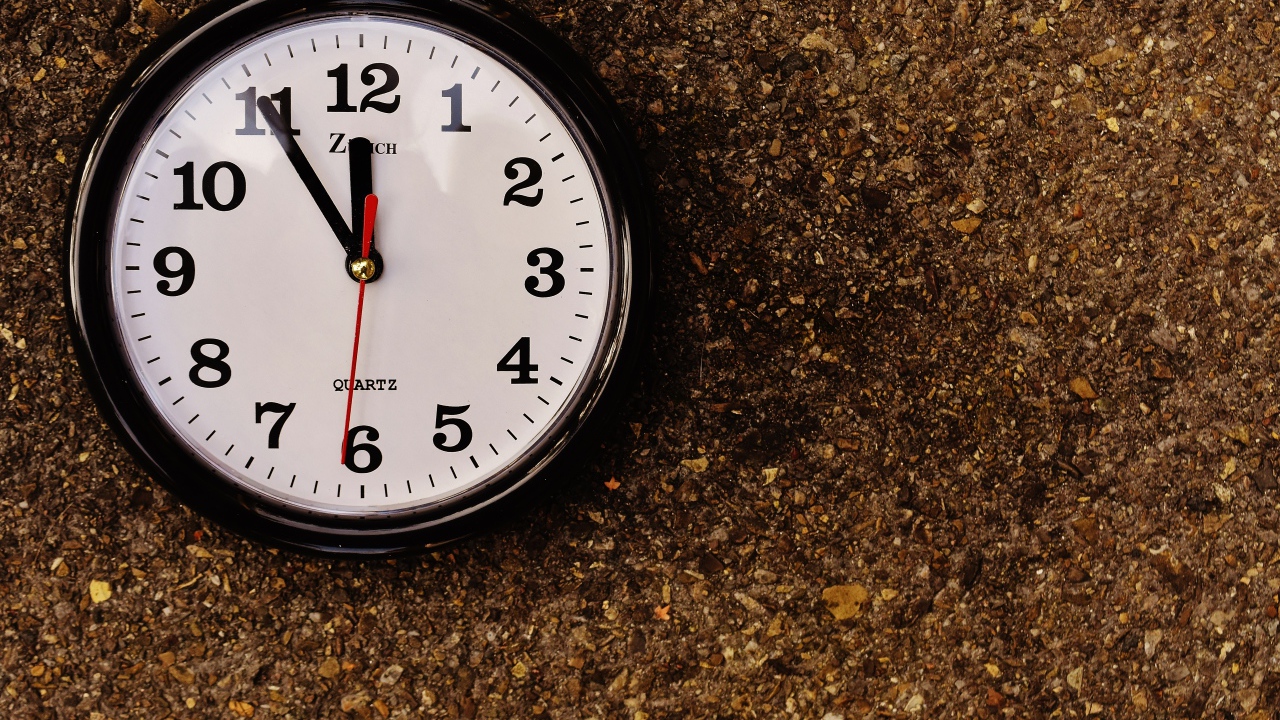 Большие черные часы висят на стене 