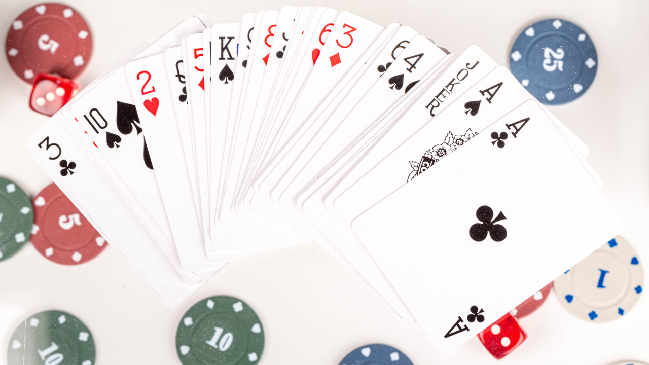 Колода игральных карт и фишки на столе в казино 