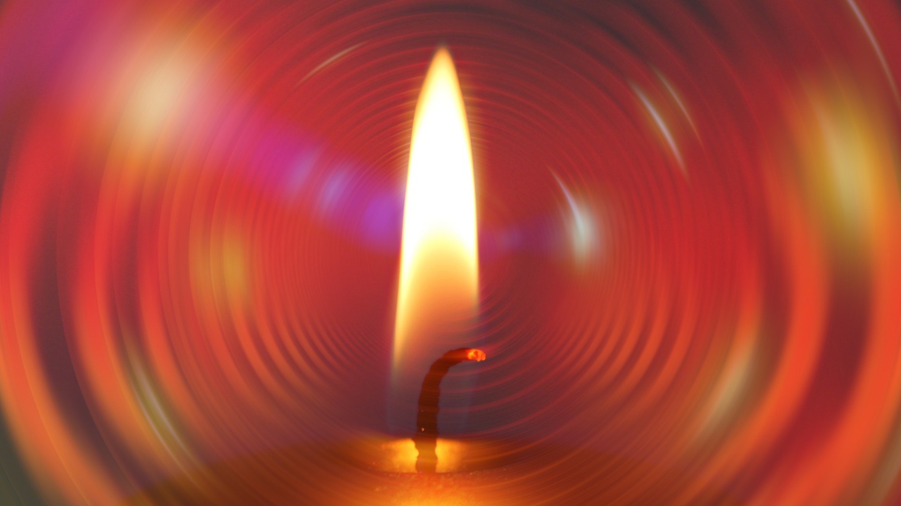 Огонь свечи на фоне красного круга 