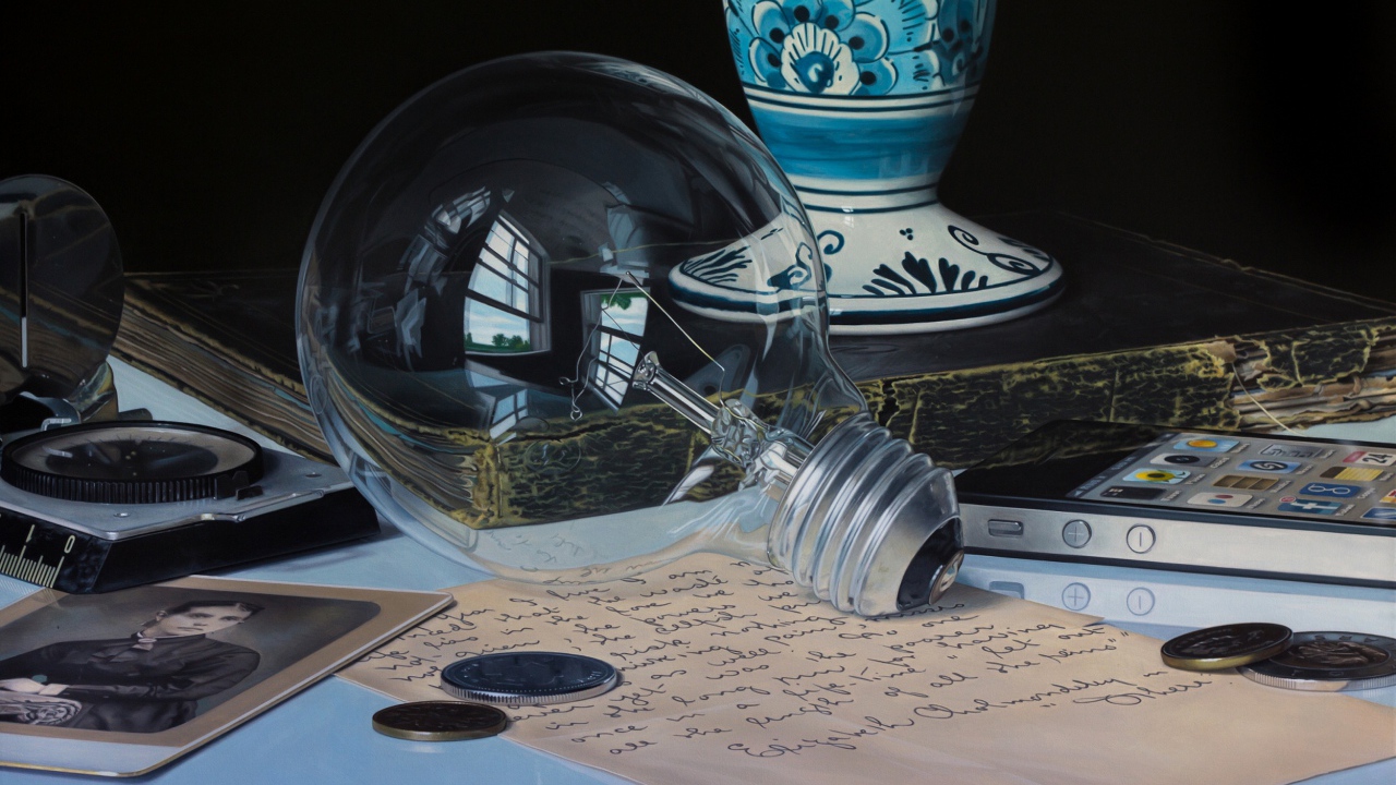 Стеклянная лампочка на столе с монетами и письмом