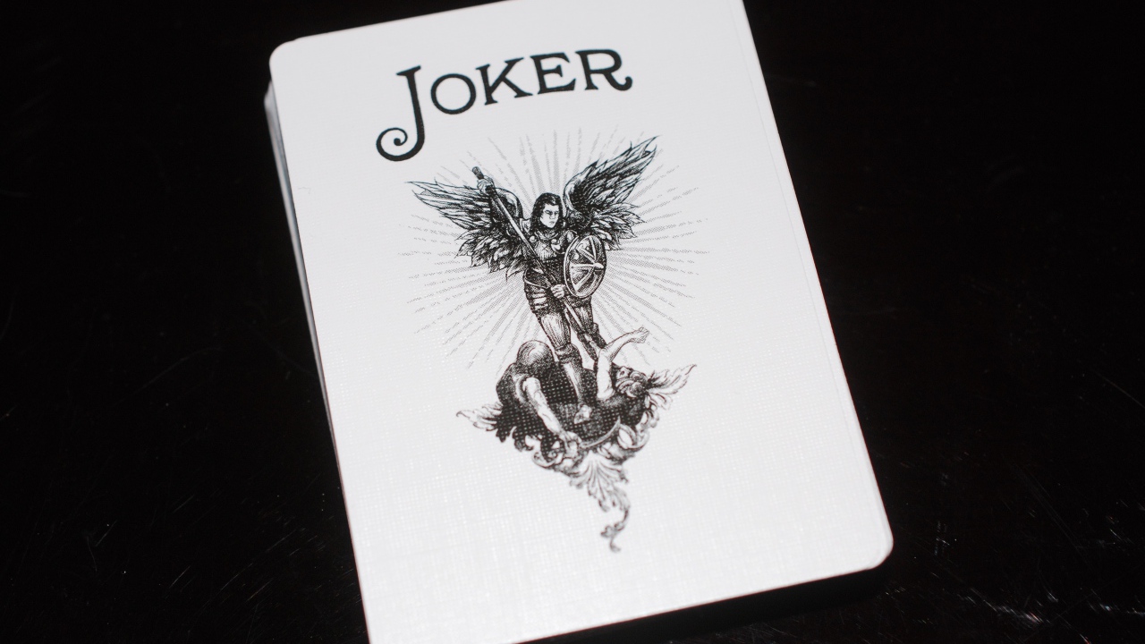 Joker card on black background on the table