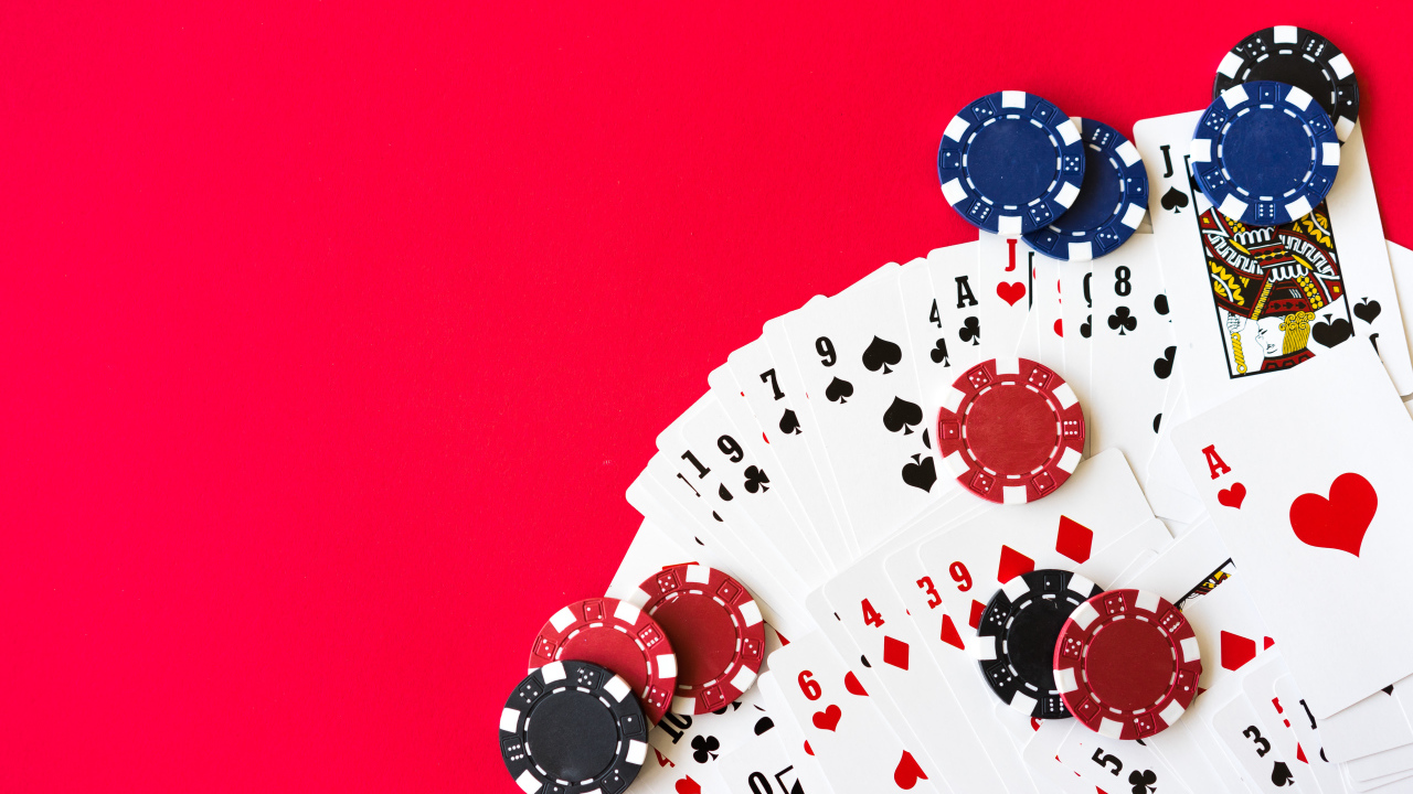 Карты для покера и фишки на красном фоне 