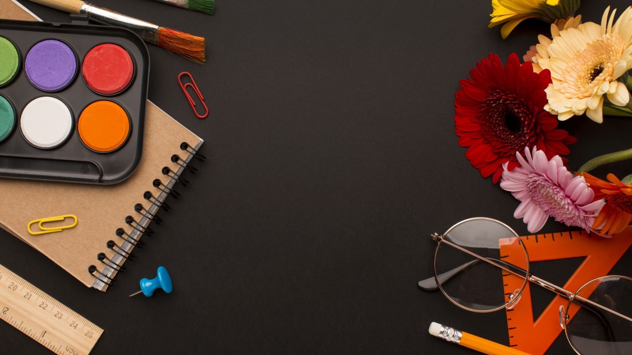 Канцелярские предметы, очки и герберы на черном фоне 