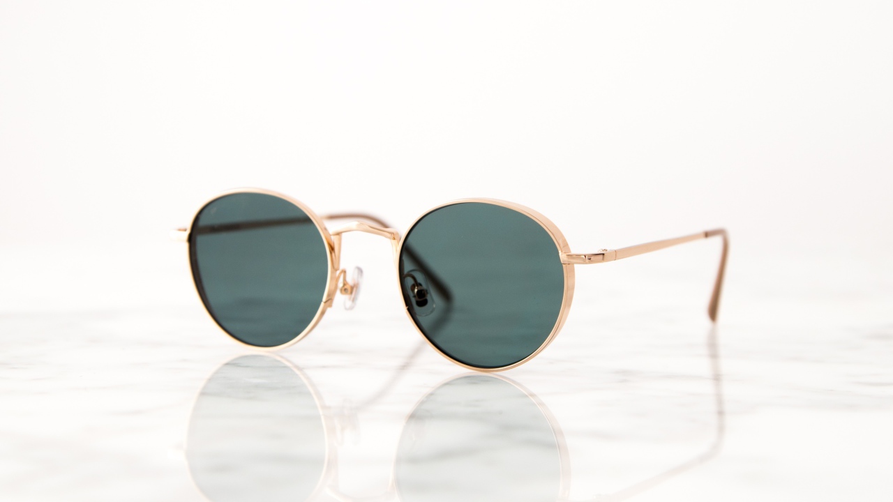 Солнечные очки лежат на зеркальной поверхности