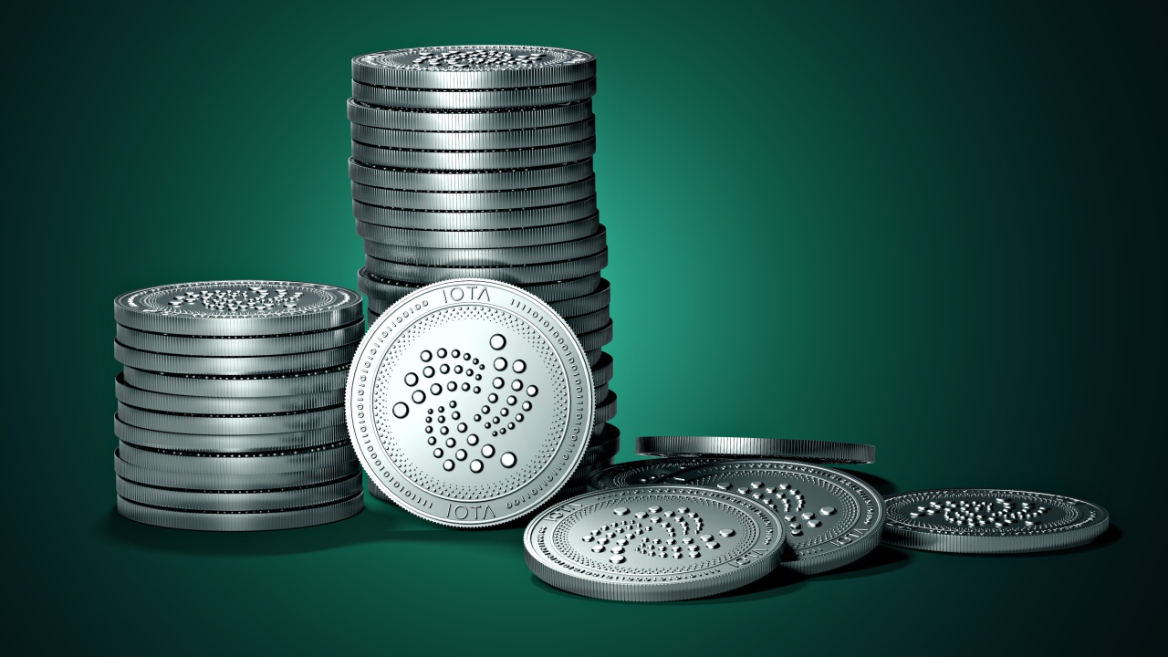 Монеты IOTA на зеленом фоне