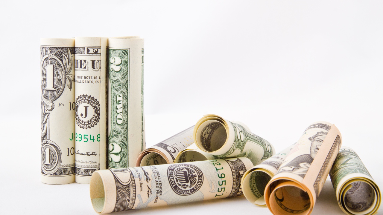 Скрученные в трубочки доллары на белом фоне 