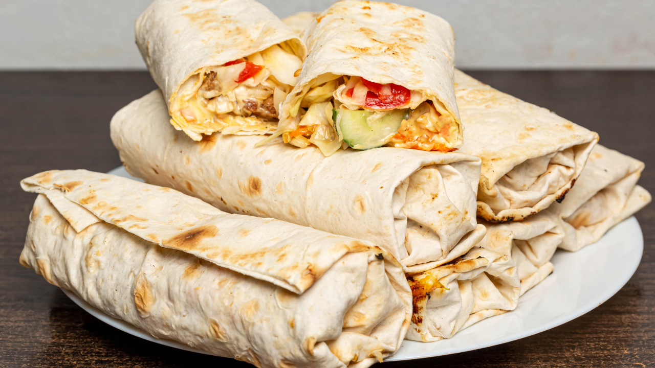 Аппетитная шаурма в лаваше на столе 