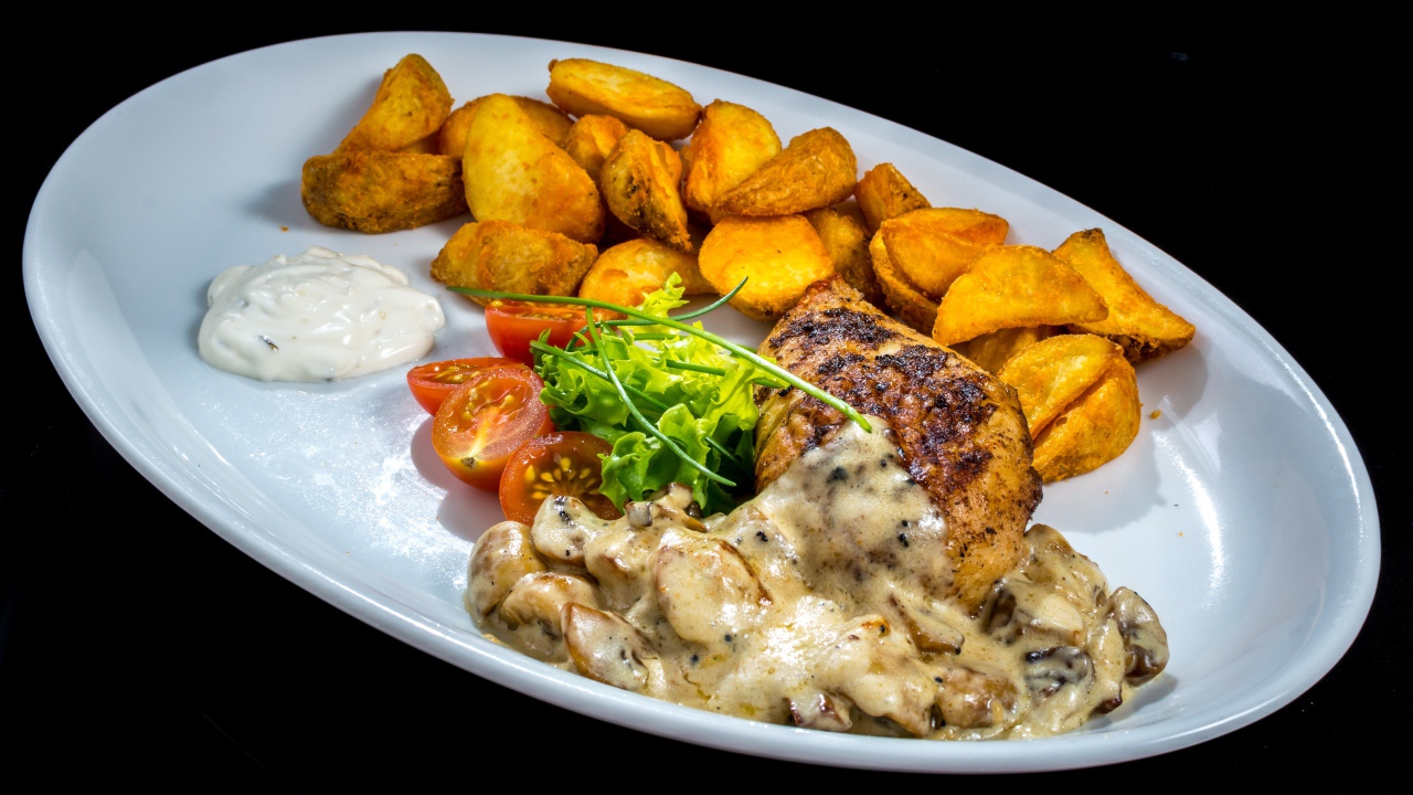 Запеченный картофель с грибами, мясом и овощами на тарелке