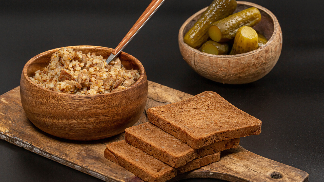 Гречка на столе с хлебом и огурцами