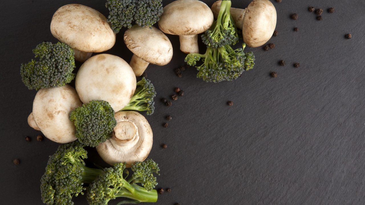 Шампиньоны с брокколи на сером столе 