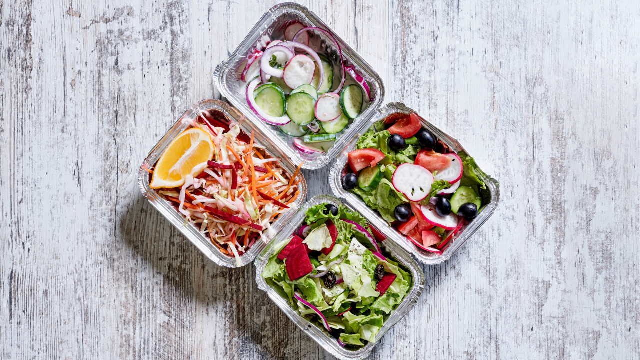 Разные овощные салаты в тарелках на сером столе 